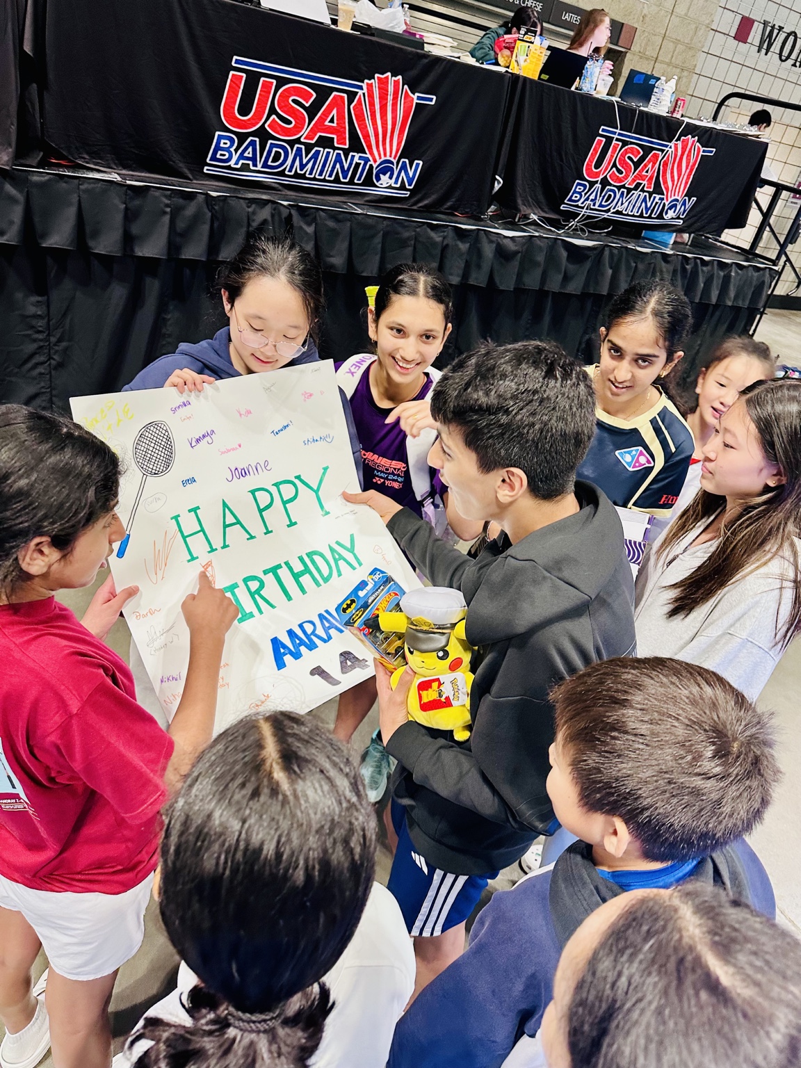 Fellow badminton players surprising Aarav with a birthday sign