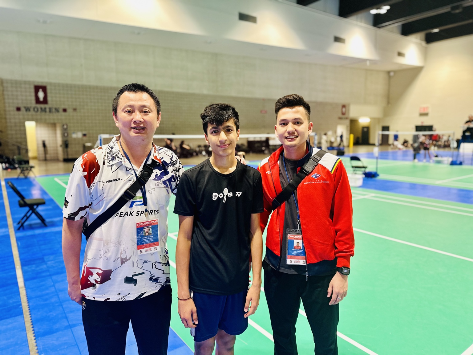 Aarav standing courtside with two coaches